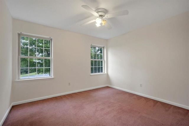 carpeted spare room with healthy amount of natural light, baseboards, and ceiling fan