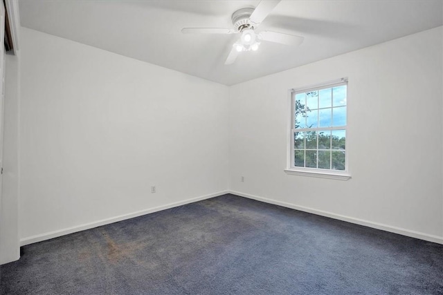 empty room with dark carpet, baseboards, and ceiling fan