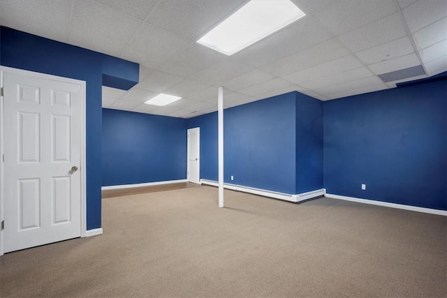 finished basement featuring carpet flooring, a paneled ceiling, baseboards, and baseboard heating