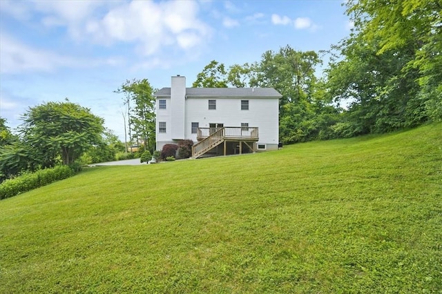 back of house featuring stairway, a chimney, a yard, and a deck