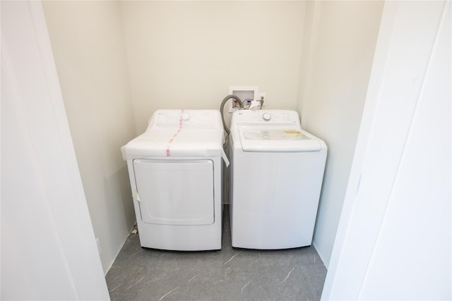 washroom with independent washer and dryer and baseboards