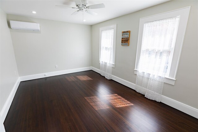 spare room with a wall mounted air conditioner, baseboards, ceiling fan, dark wood-type flooring, and recessed lighting