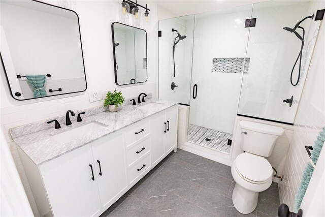 full bath with toilet, a shower stall, and double vanity
