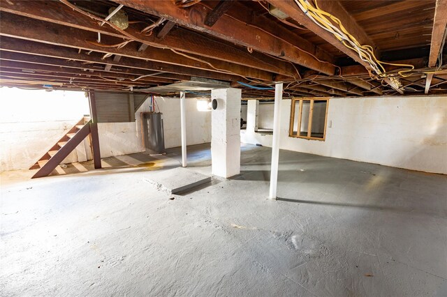 basement featuring stairs and water heater