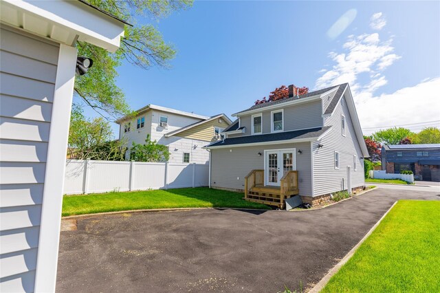 back of property with french doors and a chimney