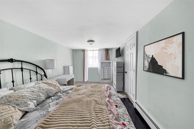 bedroom featuring a baseboard radiator, dark wood-style floors, and baseboards