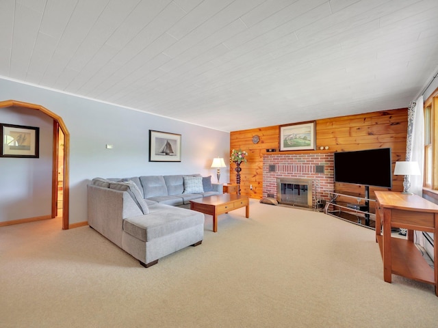 229 Eldred Yulan Rd, Eldred, NY 12792 - carpeted living area with a brick fireplace, wooden walls, baseboards, and arched walkways