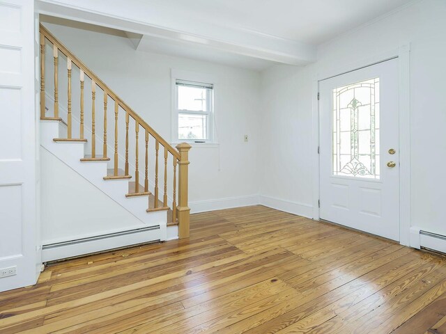 entrance foyer featuring a baseboard heating unit, light wood finished floors, stairs, and baseboards