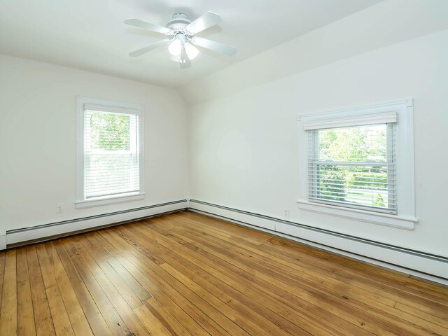 empty room featuring a baseboard radiator, light wood-style floors, ceiling fan, and lofted ceiling