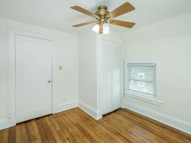 spare room with wood-type flooring, baseboards, and a ceiling fan