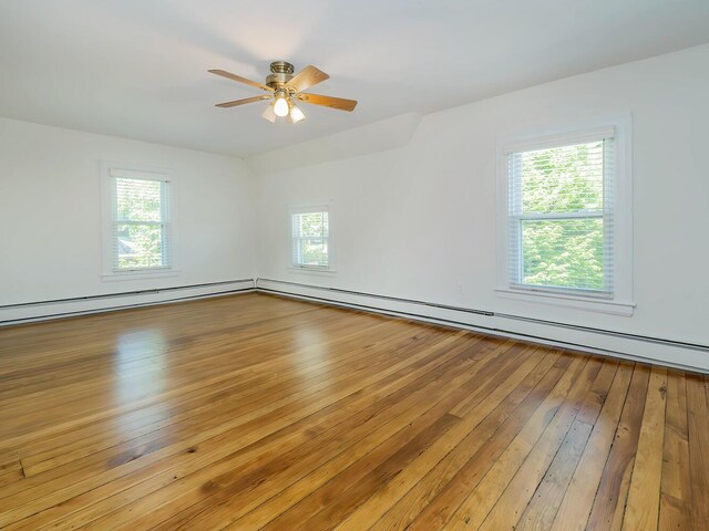spare room featuring healthy amount of natural light, wood-type flooring, and a ceiling fan