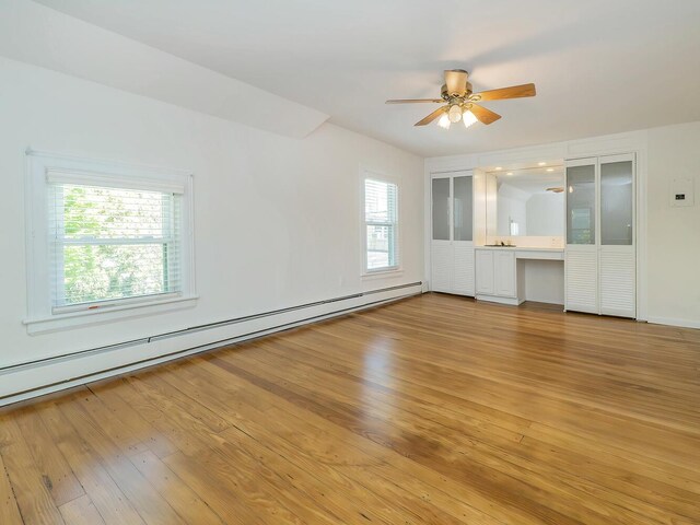 unfurnished living room with a baseboard radiator, light wood-type flooring, and a ceiling fan