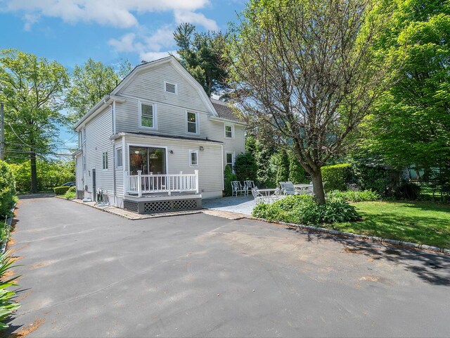 view of front of property featuring a patio and asphalt driveway