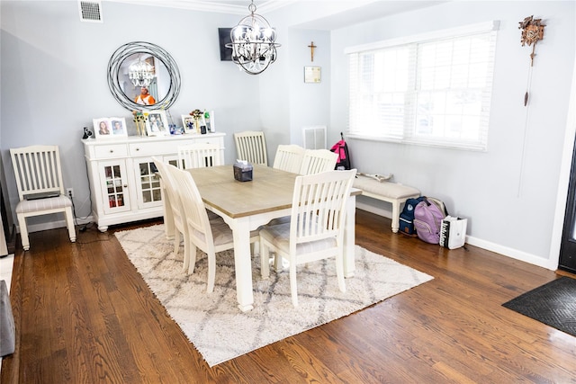 dining room featuring a chandelier, wood finished floors, baseboards, and ornamental molding