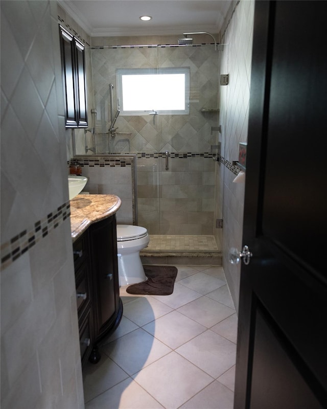 bathroom with a shower stall, vanity, ornamental molding, toilet, and tile patterned floors