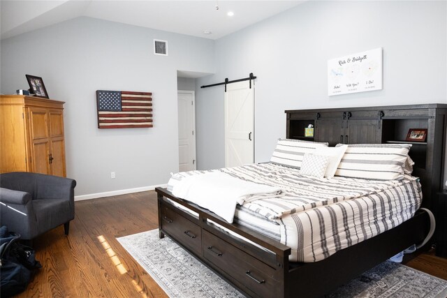 bedroom with a barn door, dark wood finished floors, baseboards, and lofted ceiling