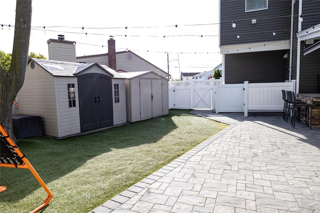 view of yard with a storage unit, a gate, a patio area, an outdoor structure, and central AC unit