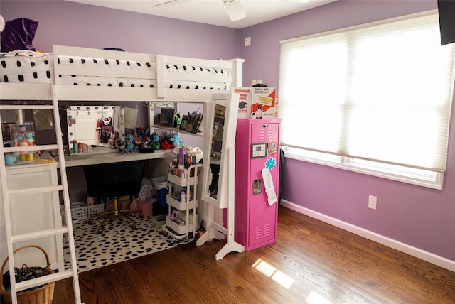 bedroom featuring multiple windows, wood finished floors, and baseboards