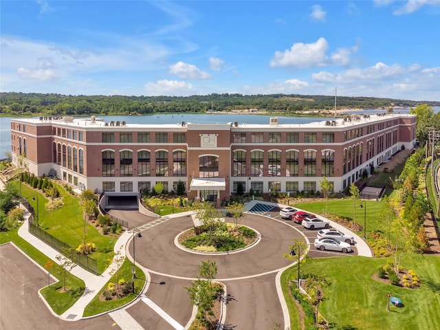 view of apartment building / complex with uncovered parking and a water view