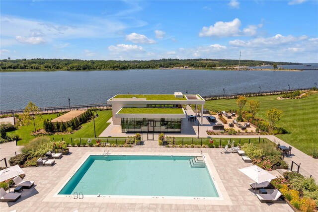 community pool featuring a water view, fence, and a patio area