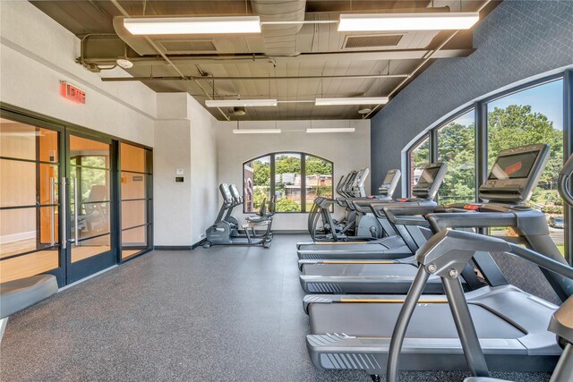 workout area with baseboards and a towering ceiling