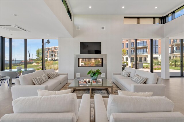 living room with a towering ceiling, expansive windows, and recessed lighting