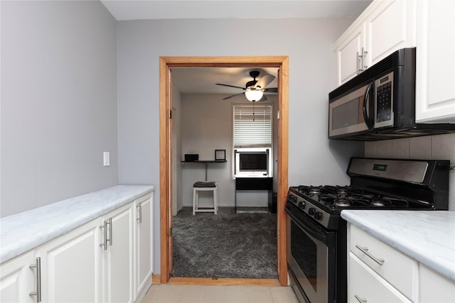 58-03 Calloway St Unit 3Nn, Corona, NY 11368 - kitchen featuring gas range, white cabinetry, ceiling fan, light stone countertops, and light colored carpet