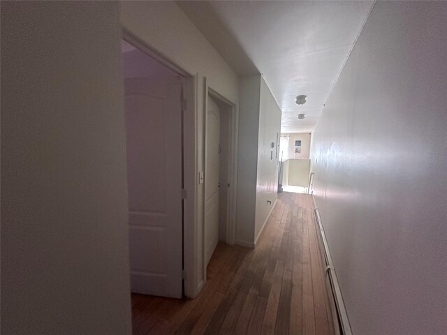 1903 Arnow Ave, Bronx, NY 10469 - corridor with dark wood-type flooring, a baseboard heating unit, and baseboards