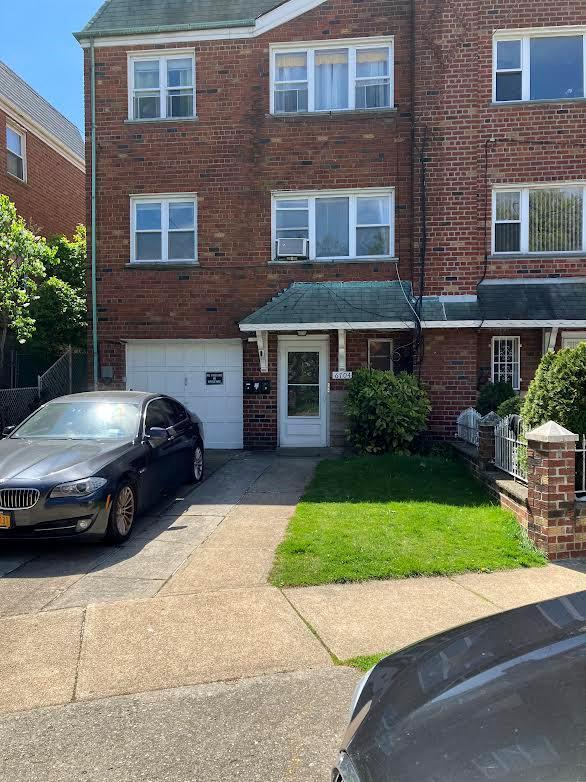 67-04 Garfield Ave, Woodside, NY 11377 - view of property with an attached garage, driveway, and brick siding