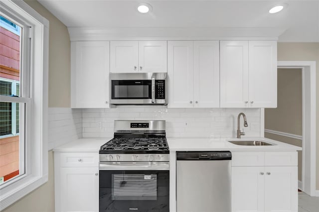 62-33 59th Dr, Maspeth, NY 11378 - kitchen with appliances with stainless steel finishes, a sink, light countertops, white cabinetry, and recessed lighting