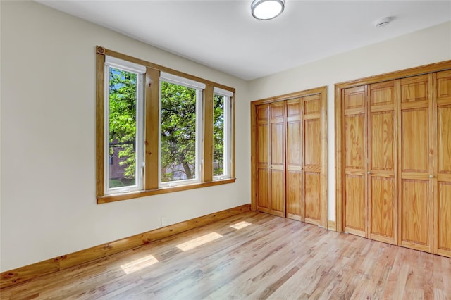 62-33 59th Dr, Maspeth, NY 11378 - unfurnished bedroom with two closets, light wood-style floors, and baseboards