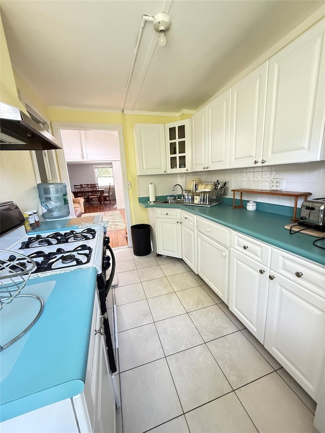 37 New Ave, Yonkers, NY 10704 - kitchen featuring gas stove, white cabinetry, light tile patterned flooring, dark countertops, and backsplash