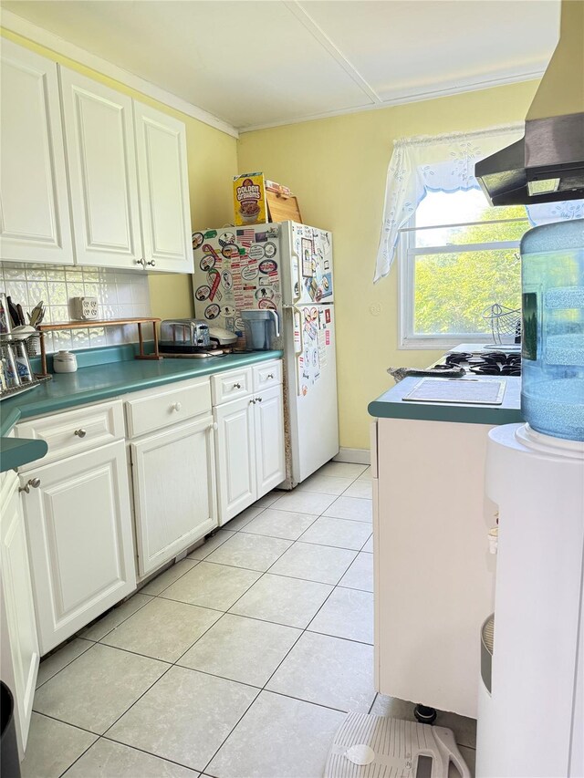 37 New Ave, Yonkers, NY 10704 - kitchen with wall chimney range hood, freestanding refrigerator, white cabinets, light tile patterned floors, and ornamental molding