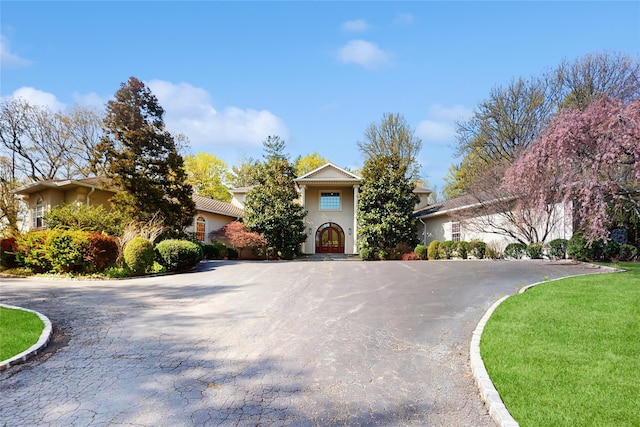 406 Duck Pond, Locust Valley, NY 11560 - view of property hidden behind natural elements with curved driveway and stucco siding