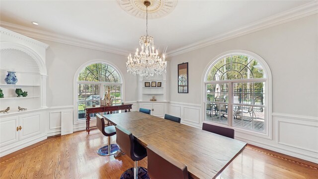 406 Duck Pond, Locust Valley, NY 11560 - dining area with healthy amount of natural light, a chandelier, light wood finished floors, a decorative wall, and ornamental molding