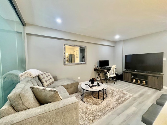 living room with wood finished floors, baseboards, and recessed lighting