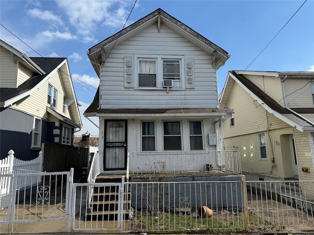 view of front of house with a fenced front yard, covered porch, and a gate