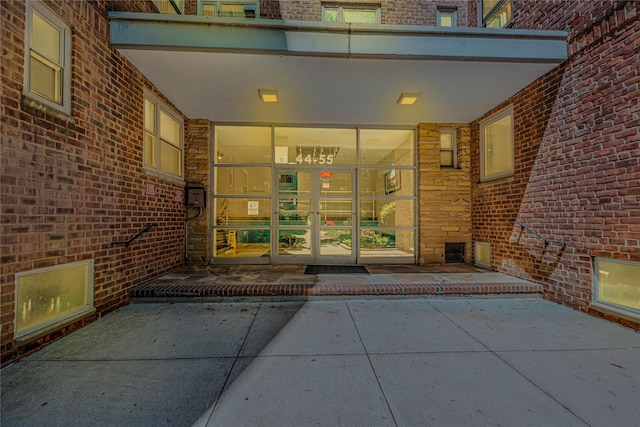 entrance to property featuring brick siding and french doors