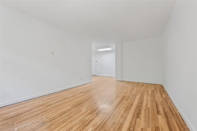 unfurnished room with light wood-style flooring and baseboards