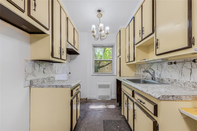 kitchen with light countertops, a sink, a chandelier, tasteful backsplash, and baseboards