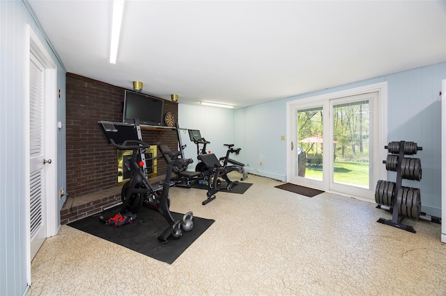 exercise room featuring a baseboard radiator and brick wall