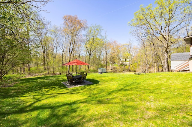 view of green lawn featuring a shed and an outdoor structure