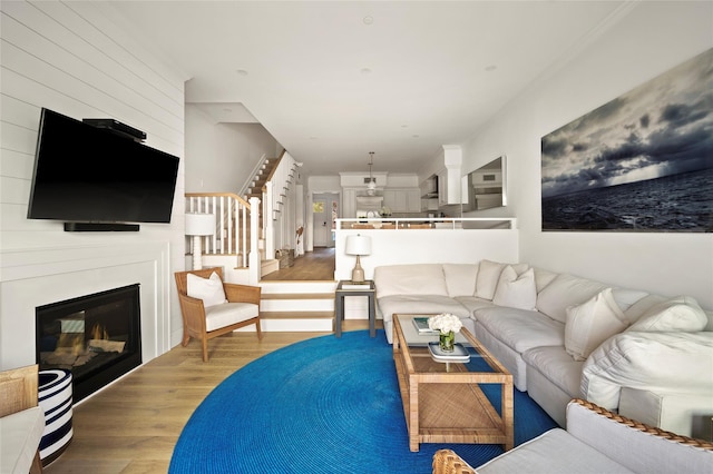 67 Old Boathouse Ln N, Hampton Bays, NY 11946 - living area with wood finished floors, stairway, and a glass covered fireplace