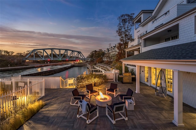 67 Old Boathouse Ln N, Hampton Bays, NY 11946 - patio terrace at dusk featuring an outdoor fire pit and a water view