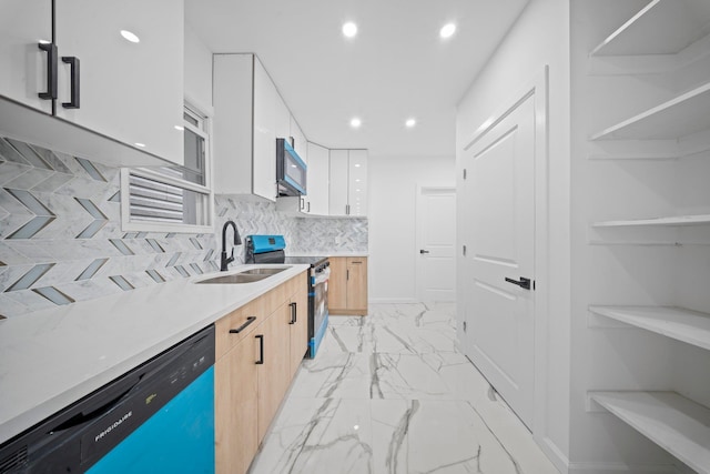 kitchen featuring appliances with stainless steel finishes, a sink, light marble finish flooring, modern cabinets, and white cabinetry