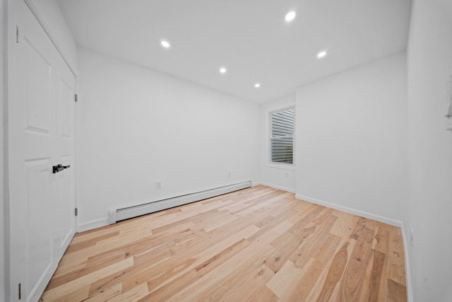 unfurnished room featuring a baseboard radiator, recessed lighting, wood finished floors, and baseboards
