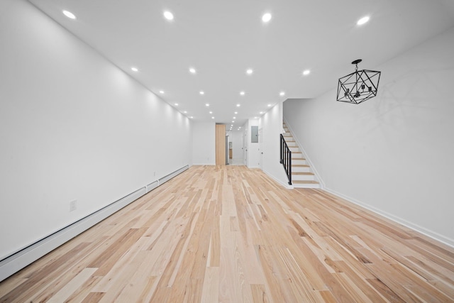 unfurnished living room with baseboard heating, stairs, light wood finished floors, recessed lighting, and baseboards