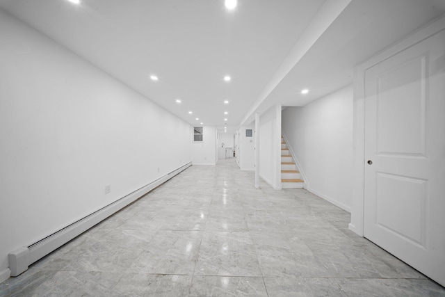 finished basement with a baseboard heating unit, stairs, recessed lighting, and baseboards