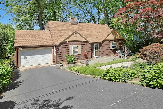 7 Southminster Dr, White Plains, NY 10604 - view of front of home with roof with shingles, a chimney, an attached garage, and asphalt driveway