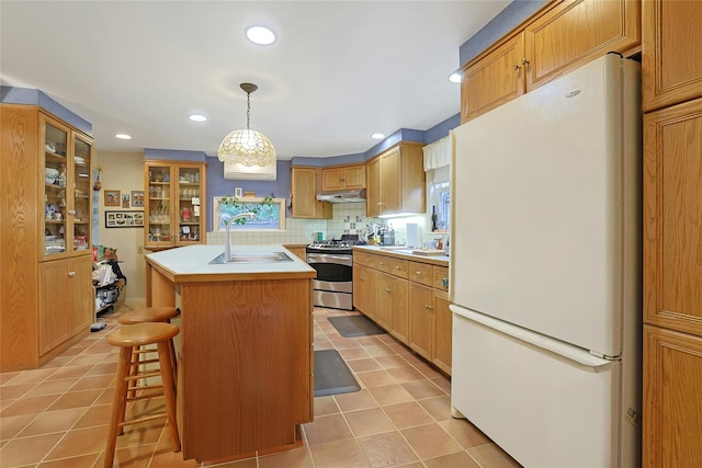 7 Southminster Dr, White Plains, NY 10604 - kitchen with freestanding refrigerator, a sink, gas stove, under cabinet range hood, and light tile patterned flooring